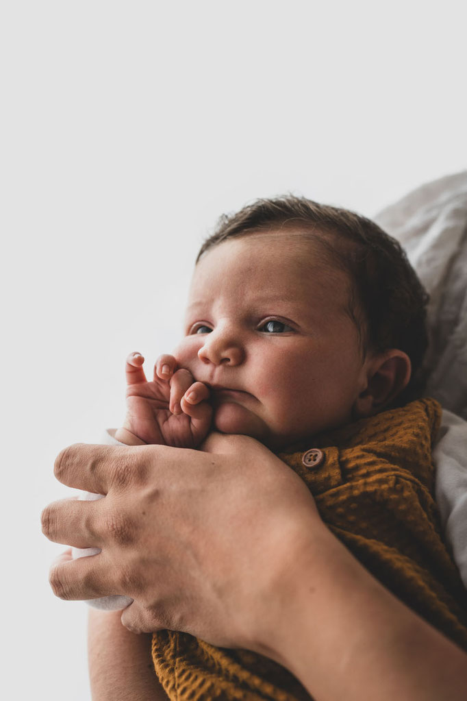 baby auf arm, senffarbener strampler