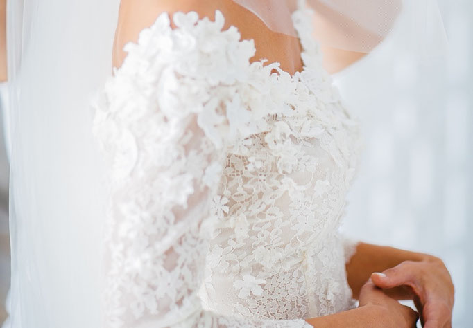 Brautkleid von Paulina Oberteil mit Applikationen aus vier verschiedenen  Spitzen eng geraffter Chiffonrock mit Knöpfchen um die Taille Detail