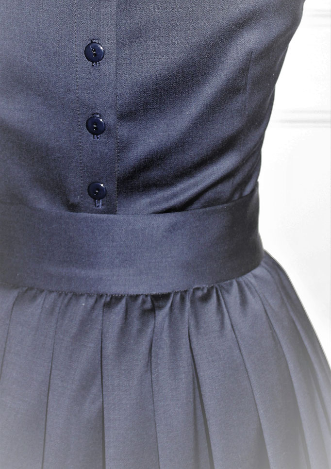 blaues Wollsatinkleid mit Faltenrock und blauer Schärpe Oberteil hinten geknöpft Detailfoto hinten