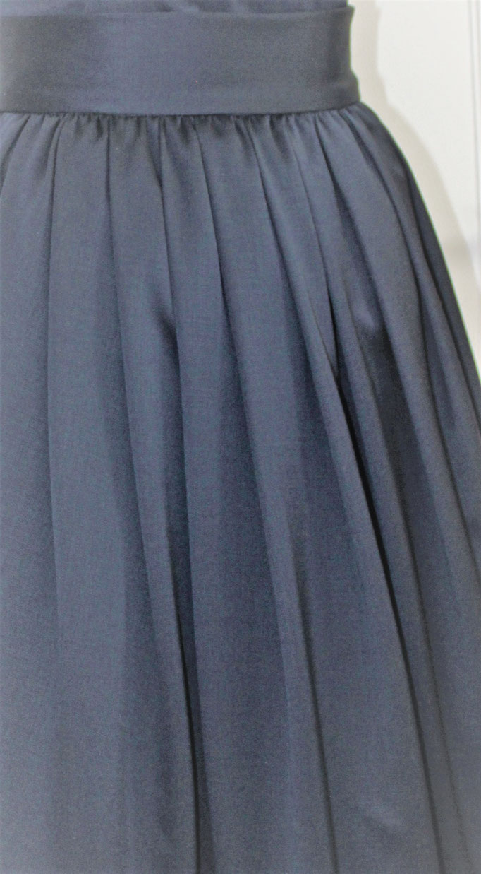 blaues Wollsatinkleid mit Faltenrock und blauerSchärpe Oberteil hinten geknöpft Detailfoto Rock