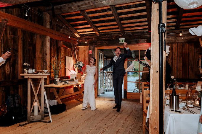 Das Brautpaar kommt Jubelnd in die Hochzeitslocation Wasmeier. Hochzeitsreportage von den Hochzeitsfotografen Andreas Reiter und Manuela Reiter am Schliersee. 