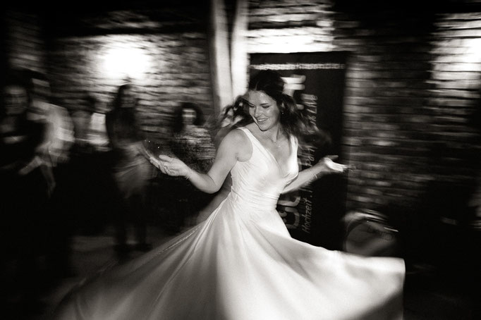 Die Braut dreht sich während des Tanzens und ihr Brautkleid schwingt