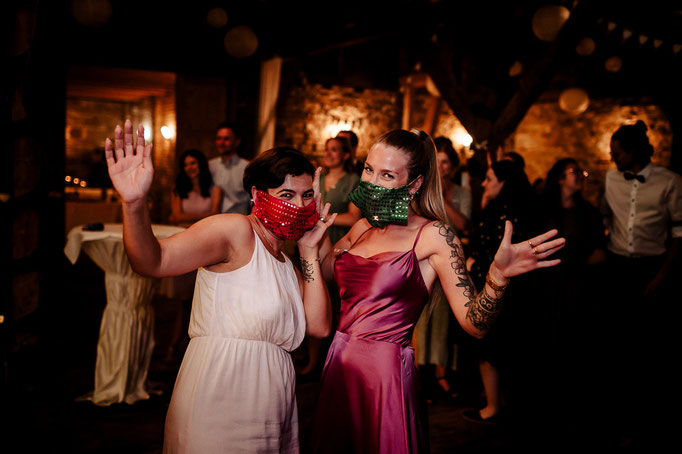 Zwei weibliche Hochzeitsgäste mit glitzernden orientalischen Tüchern im Gesicht