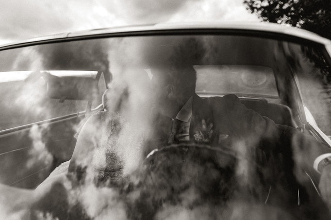 Hochzeitsfotograf Andreas Reiter fotografiert durch die Frontscheibe eines Ford Mustang, dass sich küssende Brautpaar.