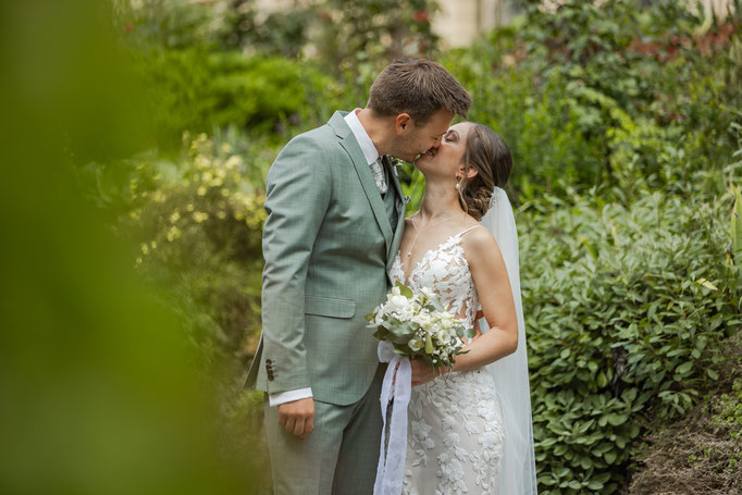 Brautpaar küsst sich beim Fotoshooting am Hochzeitstag