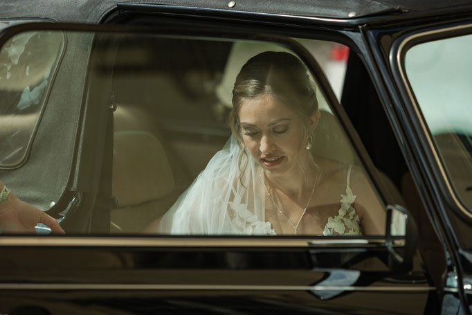 Braut steigt aus dem Hochzeitsauto