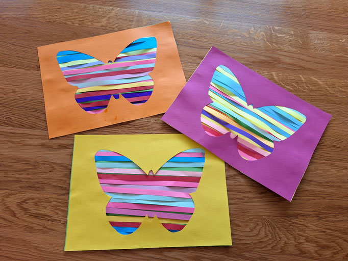 Schmetterlingsformen ausgeschnitten und mit bunten Papierstreifen beklebt