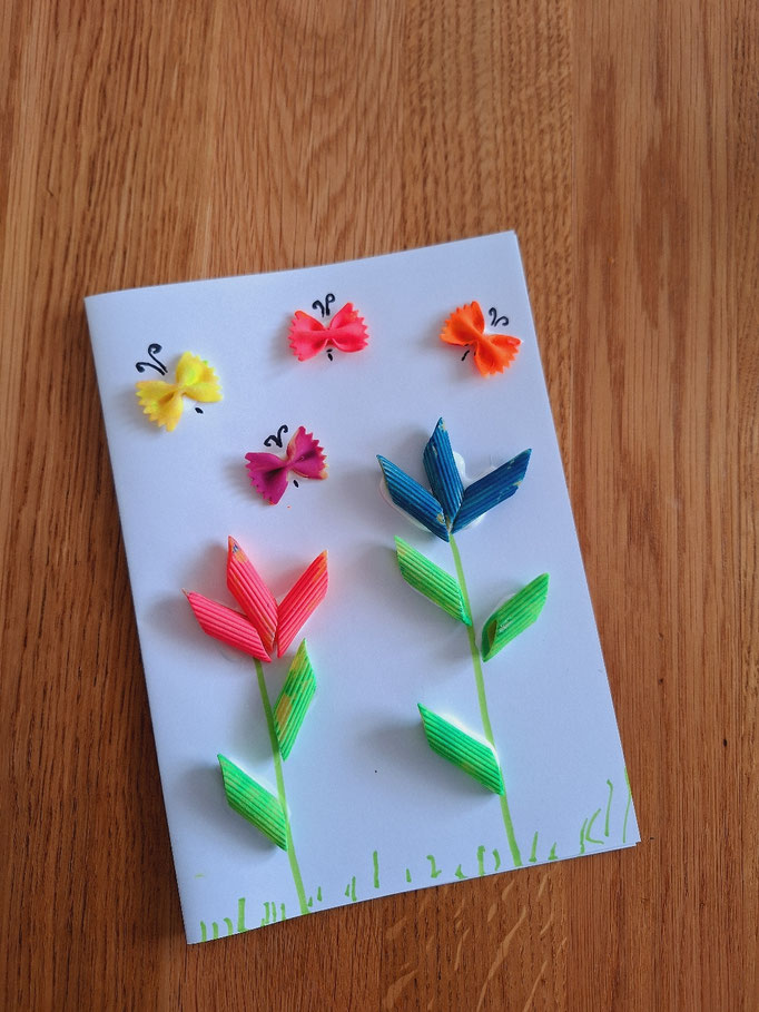 Bild aus angemalten Nudeln mit Blumen und Schmetterlingen