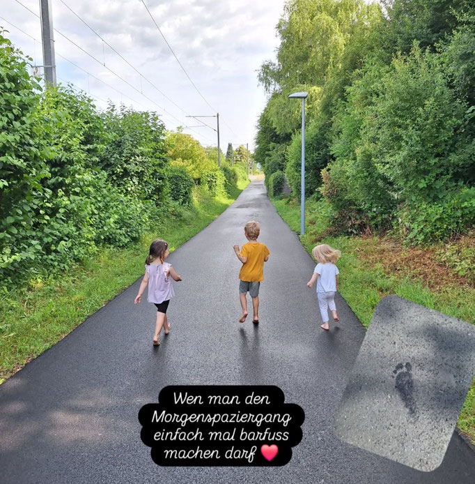 Kinder von hinten barfuss beim Spaziergang nach einem Sommerregen