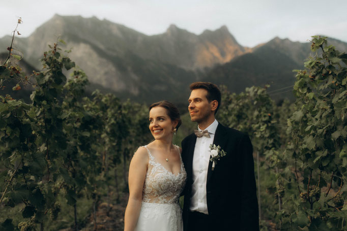 Braut und Bräutigam vor Weinreiben und Bergkulisse