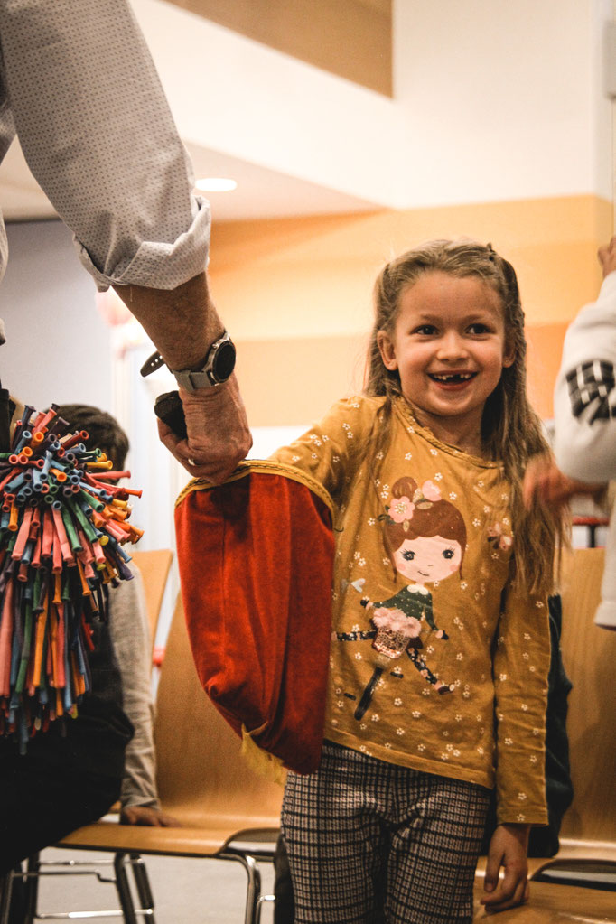 Lachendes Kind während einer Zaubershow auf einem Kindergeburtstag