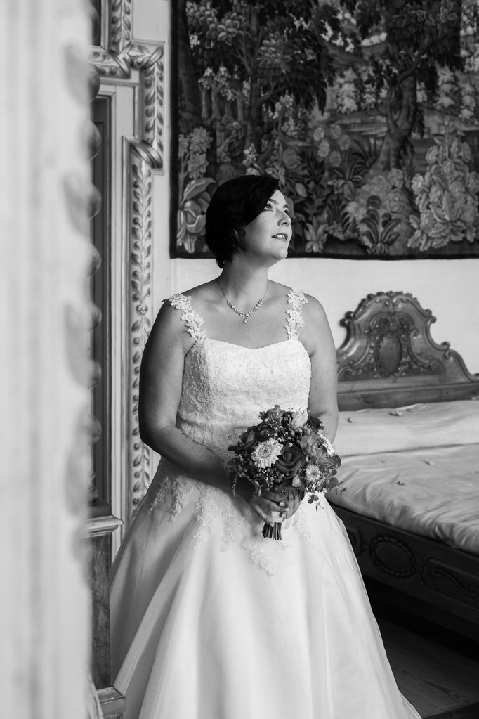 Schwarz-weiss Fotografie einer glücklichen Braut mit Brautstrauss
