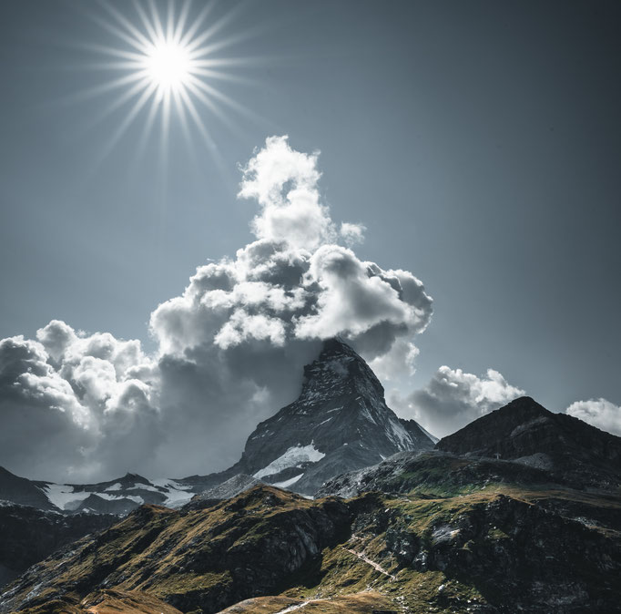 Dramatische Naturfotografie vom Matterhorn eingehüllt in Wolken mit strahlender Sonne