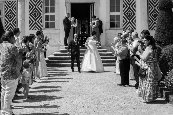 Schwarz-weiss Fotografie eines frisch vermählten Brautpaars im Empfang der Hochzeitsgesellschaft