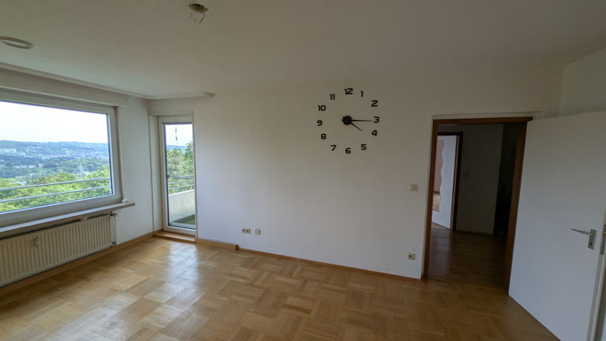 Wohnzimmer mit Balkonaustritt und Echtholz-Parkett