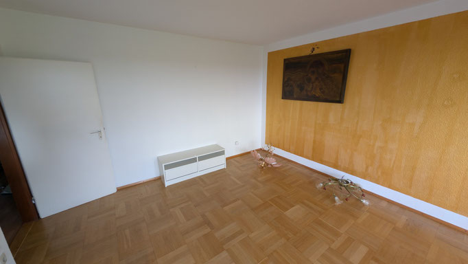 Wohnzimmer mit Balkonaustritt und Echtholz-Parkett