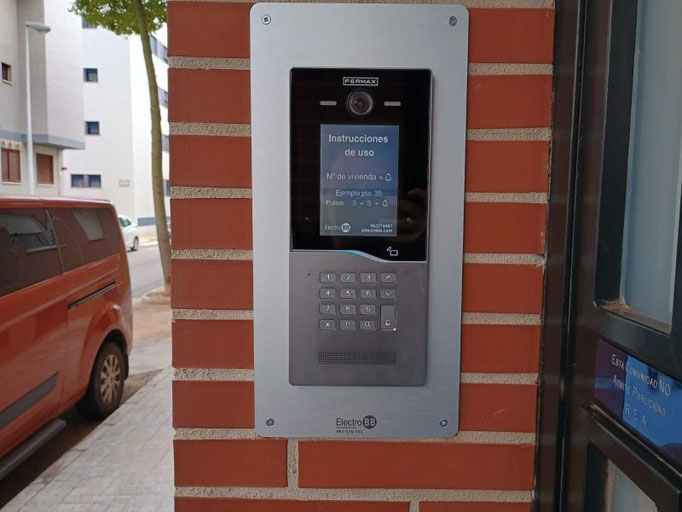 Instalación de placa de videoportero Cora con marco embellecedor sobre ladrillo rojo en Manises