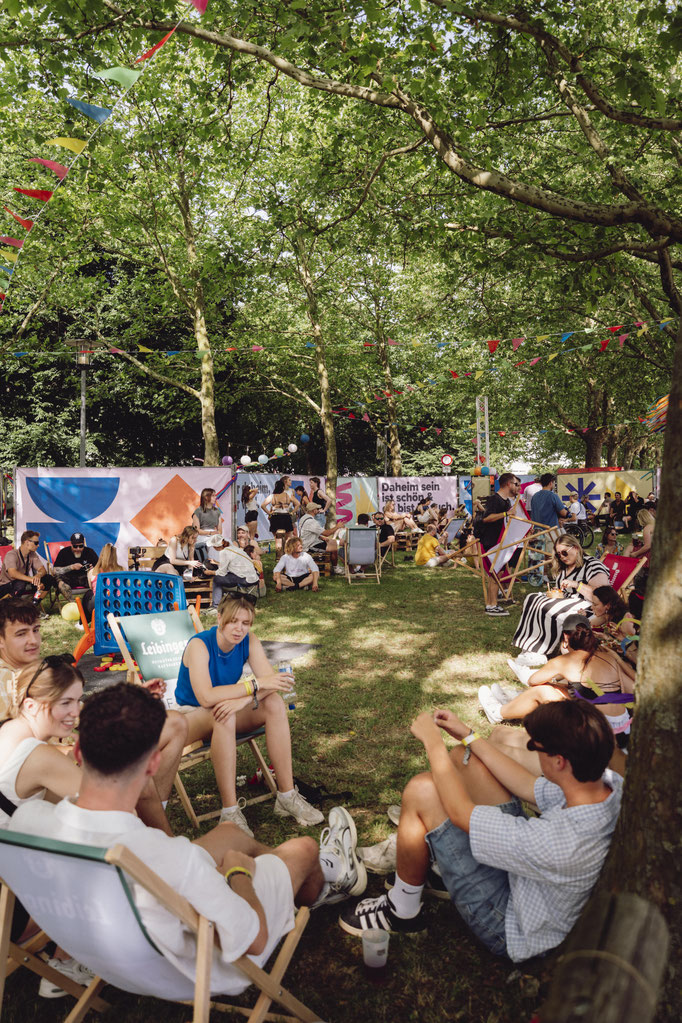Menschen nehmen sich eine auszeit in der chill out area in weingarten auf dem Daheim Festival