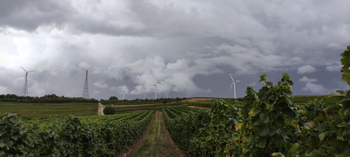 Wolkenberge türmen sich über den Windrädern auf. 