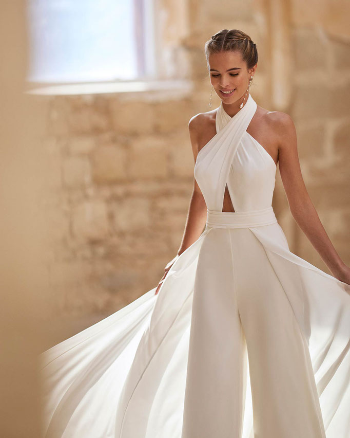 Junge Frau mit dem Brautkleid Jumpsuit Hadara aus der Alma Novia Kollektion 2026