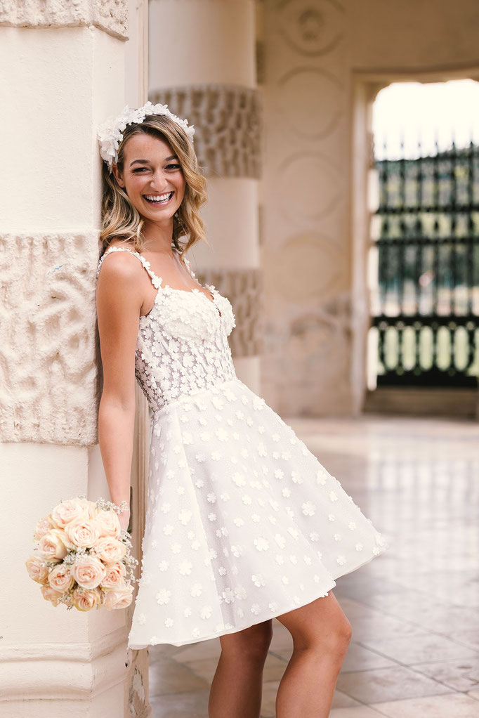 Junge blonde Frau trägt das Brautkleid Caitlin aus der Amo&Luv Kollektion