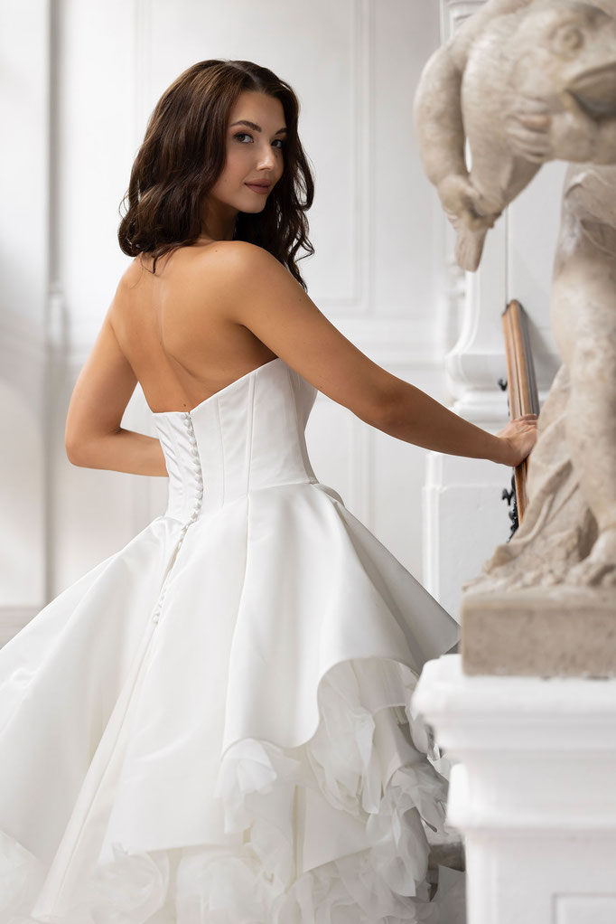 Junge elegante Frau trägt ein Brautkleid von Amo&Luv in einer klassischen Villa