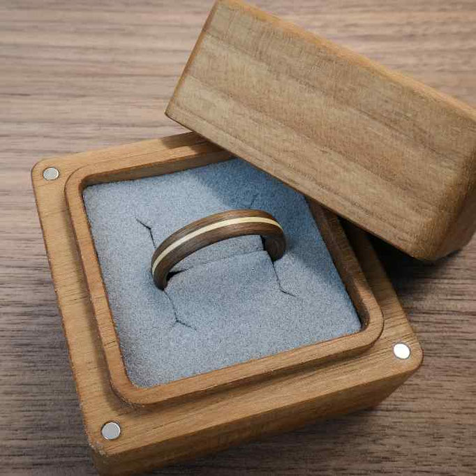 Holzring aus Nuss mit umlaufender Ahornlinie in eckiger Ringbox aus Nuss