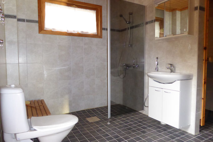 Ebenerdige Dusche, WC, Waschbecken, Spiegelschrank, genügend Ablageflächen.