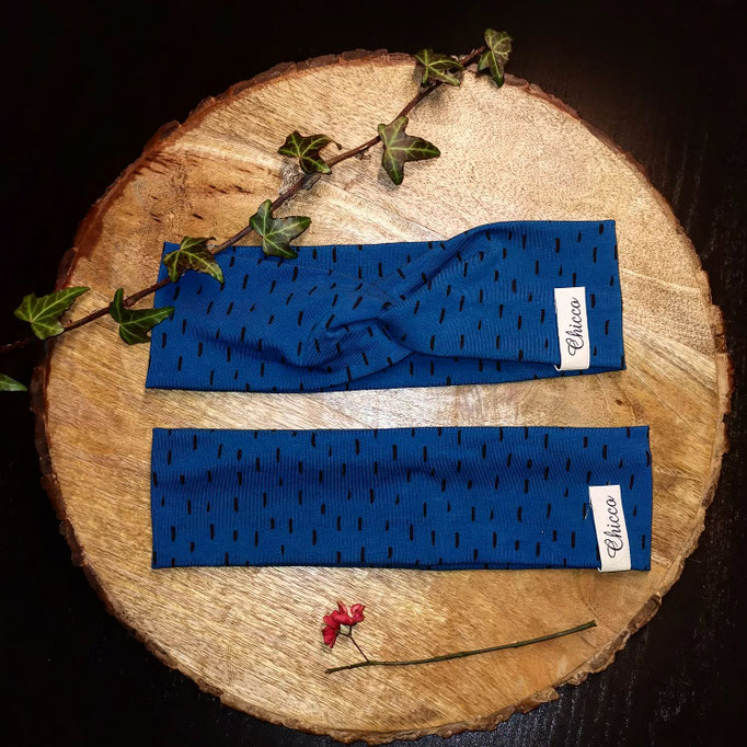 Stirnband mit und ohne Knoten in Farbe blau mit schwarzen Strichen.