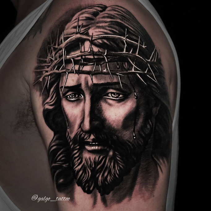 Tatuaje de Jesucristo realista en el brazo.