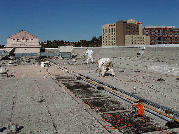 Crew spraying Ceramic InsulSeal on a commercial Built-Up-Roof (BUR) project