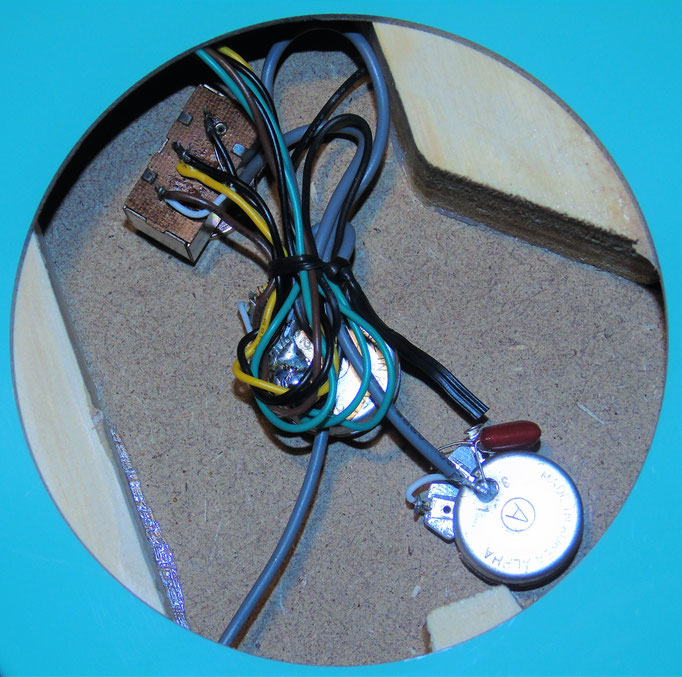 Im Hohlraum der Danelectro liegt zwischen dem Pappelholzrahmen und dem gesperrten Mittelblock auf Masonit die elektrische Schaltzentrale: 2 silberne Potentiometer zur Klangreglung und der braune "Brühwürfel" zur Anwahl von Hals- und Stegtonabnehmer.