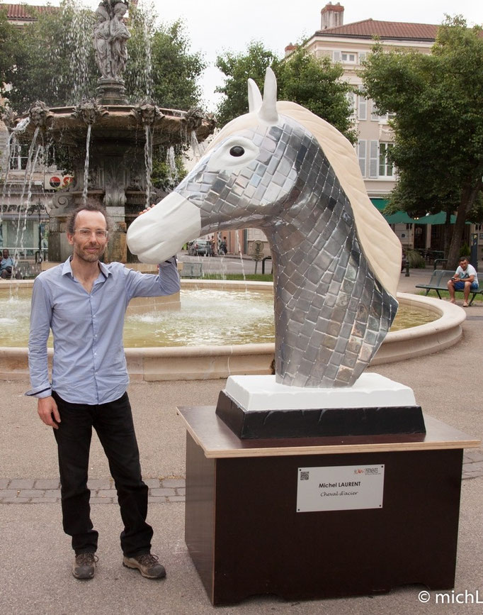 sculpture en acier en forme de tête de cheval à côté du sculpteur