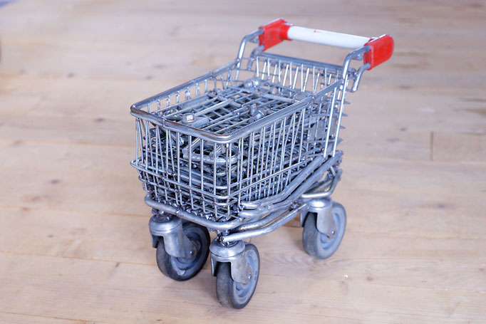 sculpture en acier représentant un petit chariot de supermarché