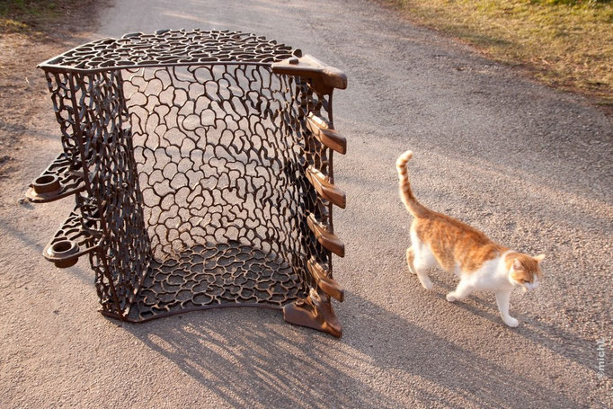 Sculpture en acier réalisée avec un godet de pelleteuse et présence d'un chat