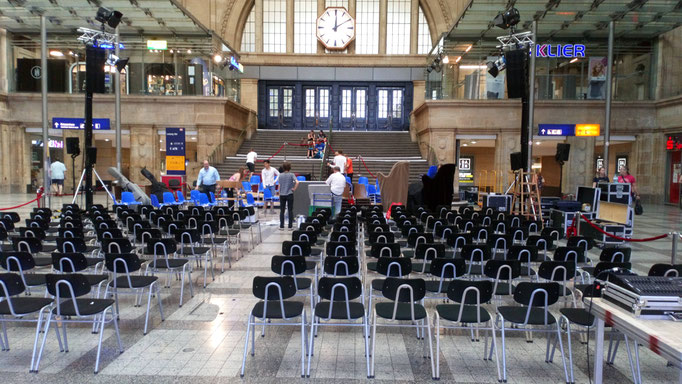 Die Stühle sind aufgestellt, das Orchester bringt die Instrumente. 