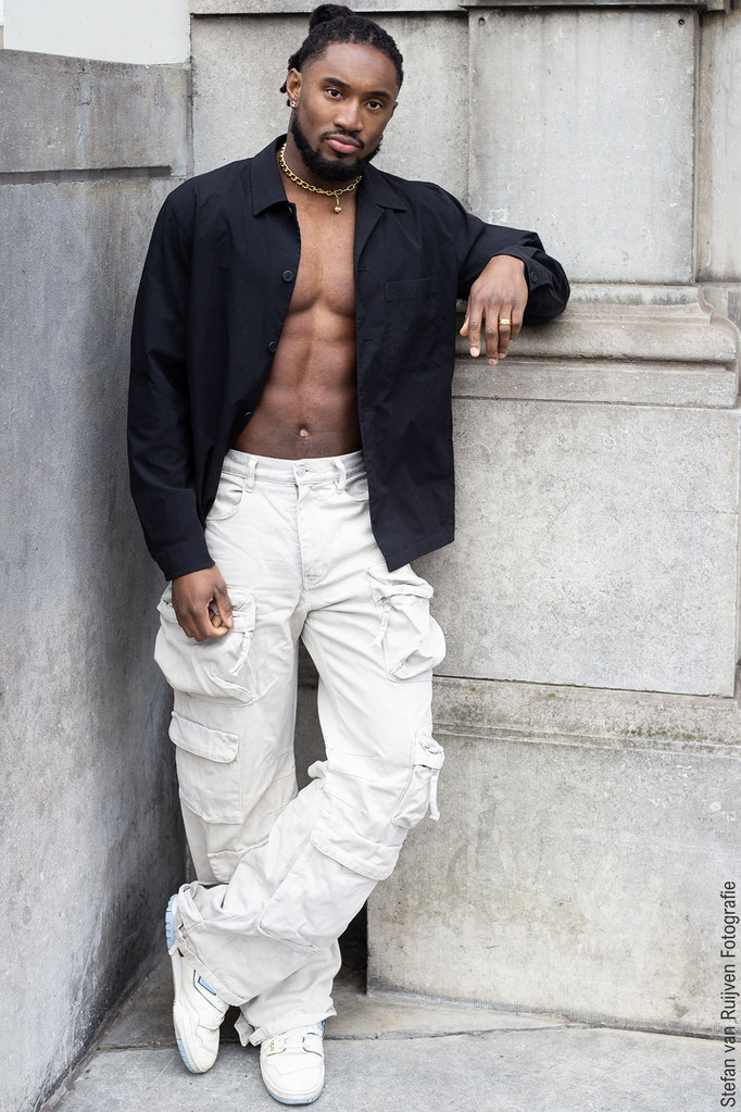 Foto's voor het portfolio van Chauncey gemaakt om zijn profiel een update te geven. Hij draagt een lichte cargo broek met sneakers  en een zwarte tanktop met gouden sieraden. Chaucey is flink gespierd, dus je ziet goed zijn gespierd armen en fitte body.
