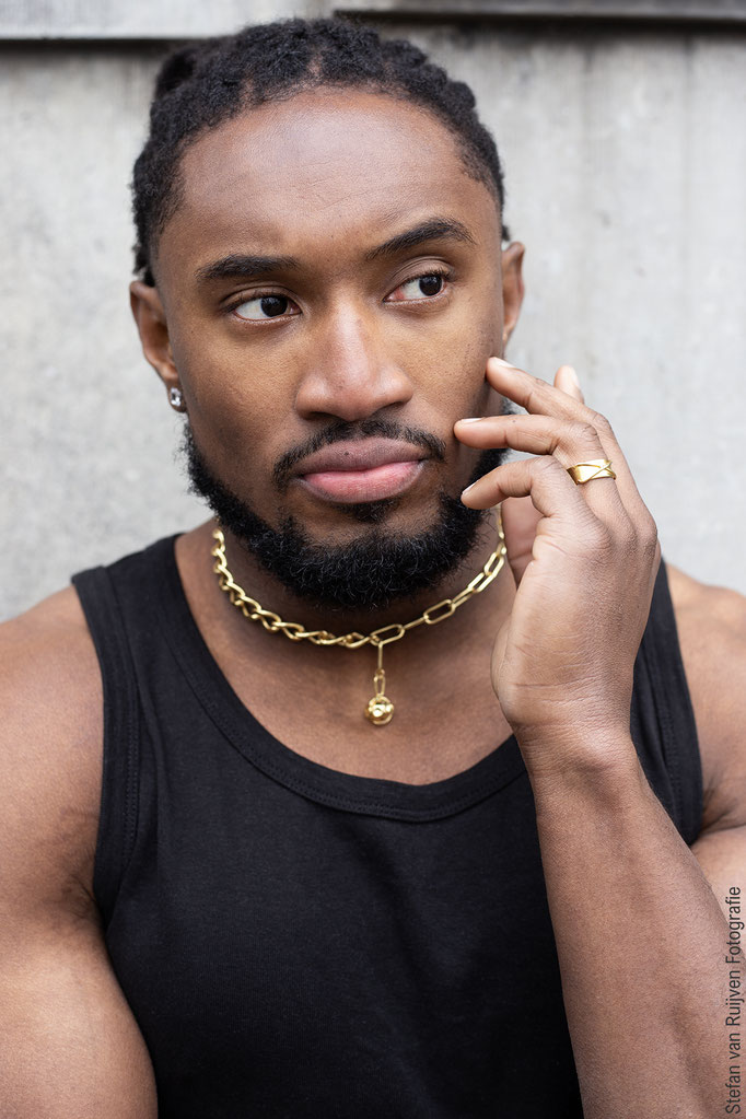 Foto's voor het portfolio van Chauncey gemaakt om zijn profiel een update te geven. Hij draagt een lichte cargo broek met sneakers  en een zwarte tanktop met gouden sieraden. Chaucey is flink gespierd, dus je ziet goed zijn gespierd armen en fitte body.