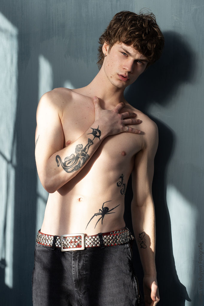 Joshua gefotografeerd in Studio 54, dit is een daglichtstudio. Mooie lichtinval door de ramen met schaduw. Hij draagt een jeans, zonder shirt en zijn tattoo's zijn zichtbaar. Stefan van Ruijven Fotografie heb de fotoshoot dag georganiseerd