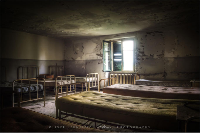 Red Cross Hospital in Italien: Ein Lost Place, dessen verlassene Gänge Geschichten stiller Hilfe erzählen. Das Foto fängt die melancholische Atmosphäre ein