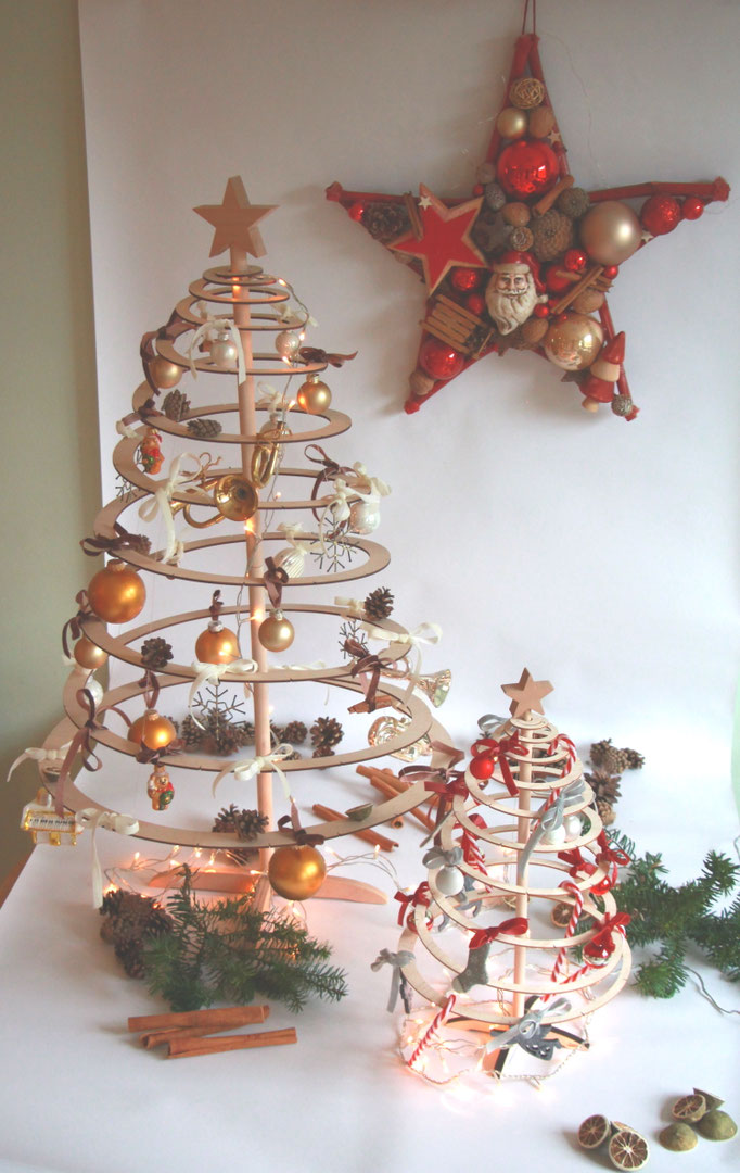 Holzbäume Spira Small und Mini mit rotem Weihnachtsmannstern im Hintergrund.
