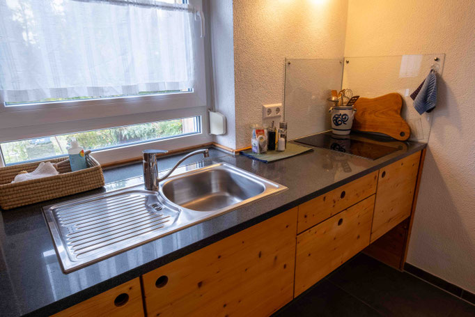 Küchenarbeitsplatte aus Stein mit eingelassenem Spülbecken und Fenster nach draußen