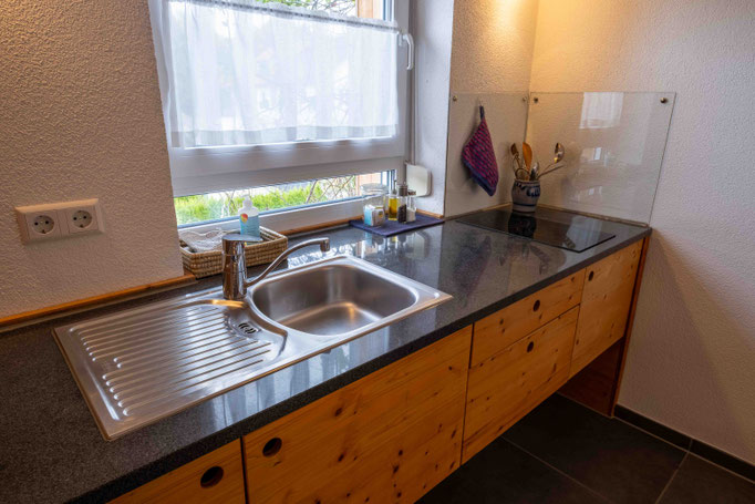 Küchenzeile aus Holz mit Unterschränken und Steinarbeitsplatte