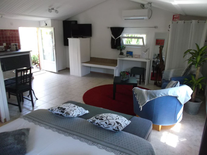 vue d'ensemble sur coin salon, bureau et espace bagages