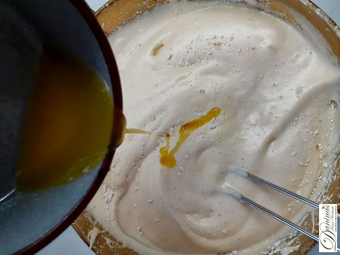 Lauwarme flüssige Butter langsam und behutsam in die Eiermasse einarbeiten