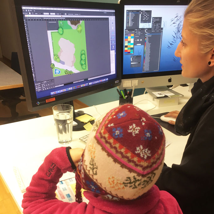 Kind und Designerin am gestalten der Spielmatte.
