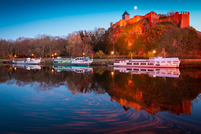 Burg Giebichenstein spiegelt sich auf der Saale im Herbst