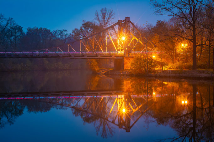 Peißnitzinselbrücke spiegelt sich am Abend auf der Saale
