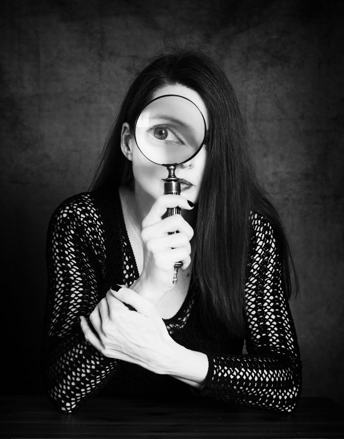 Manuela Deigert Bildsprache Selbstportrait mit Lupe vor dem Auge in schwarzweiss