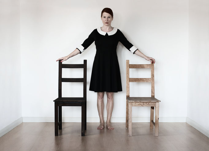 Manuela Deigert Bildsprache Selbstportrait in einem Raum zwischen zwei Stühlen